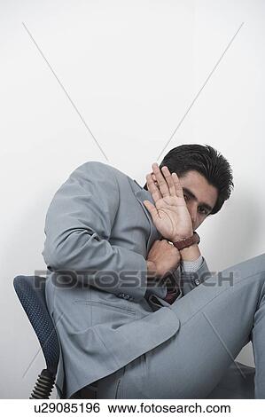 Stock Photograph - Businessman hiding himself from being photographed. Fotosearch