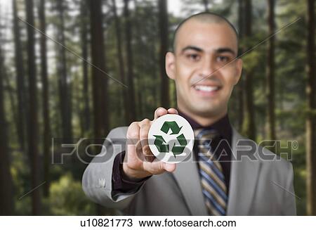 Stock Image - Businessman holding a recycling sign. Fotosearch