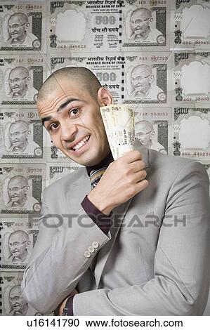 Stock Image - Businessman holding money. Fotosearch
