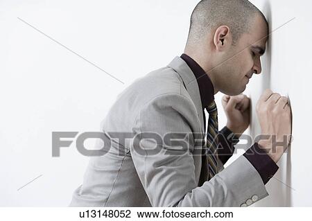 Businessman leaning his head against a wall View Large Photo Image Stock Image - Businessman leaning his head against a wall. Fotosearch