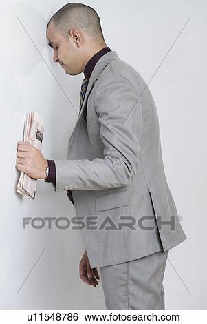 Businessman leaning his head against a wall View Large Photo Image Stock Photograph - Businessman leaning his head against a wall. Fotosearch
