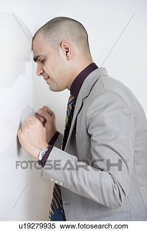 Stock Photography - Businessman leaning his head against a wall. Fotosearch