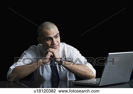Businessman looking at a laptop View Large Photo Image Stock Image - Businessman looking at a laptop. Fotosearch