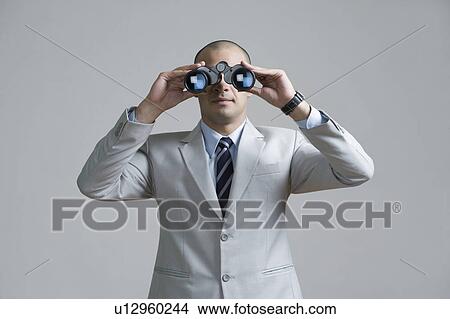 Picture - Businessman looking through binoculars. Fotosearch