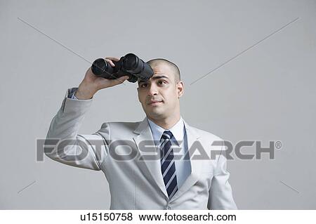 Businessman looking through binoculars View Large Photo Image Stock Photo - Businessman looking through binoculars. Fotosearch