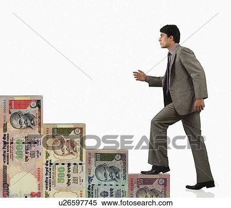Stock Photography - Businessman moving up on a staircase of money. Fotosearch