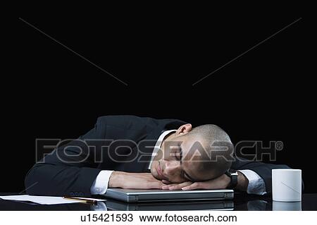 Stock Image - Businessman napping on a laptop. Fotosearch