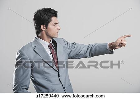 Stock Image - Businessman pointing away with finger. Fotosearch