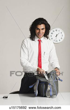 Businessman preparing to leave the office View Large Photo Image Stock Image - Businessman preparing to leave the office. Fotosearch