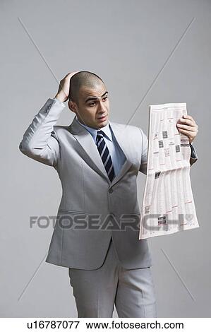 Businessman reading a financial newspaper View Large Photo Image Stock Photo - Businessman reading a financial newspaper. Fotosearch