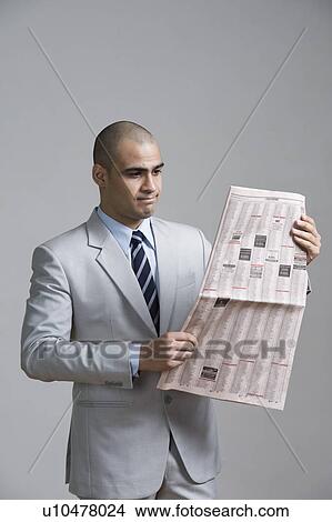 Businessman reading a newspaper View Large Photo Image Picture - Businessman reading a newspaper. Fotosearch