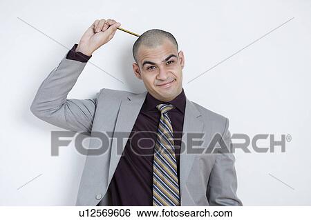 Stock Photograph - Businessman scratching his head with a pencil. Fotosearch