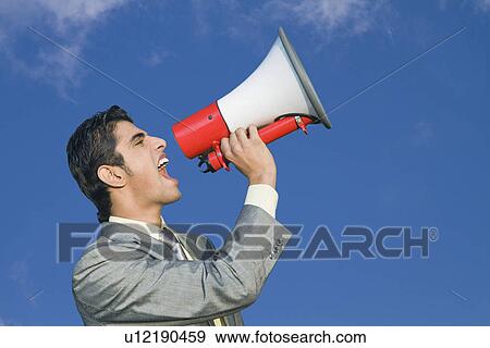 Businessman shouting into a megaphone View Large Photo Image Stock Photo - Businessman shouting into a megaphone. Fotosearch