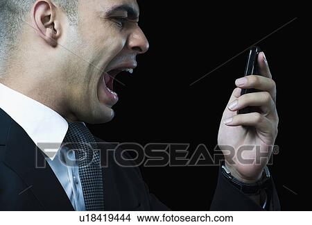 Picture - Businessman shouting on a mobile phone. Fotosearch