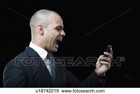 Businessman shouting on a mobile phone View Large Photo Image Stock Photo - Businessman shouting on a mobile phone. Fotosearch