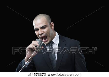Stock Image - Businessman shouting on a tin can phone. Fotosearch
