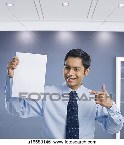 Stock Photograph - Businessman showing a blank sheet of paper. Fotosearch