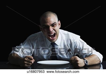 Businessman sitting at a dining table and shouting View Large Photo Image Stock Image - Businessman sitting at a dining table and shouting. Fotosearch