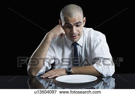 Businessman sitting at a dining table and thinking View Large Photo Image Stock Photo - Businessman sitting at a dining table and thinking. Fotosearch