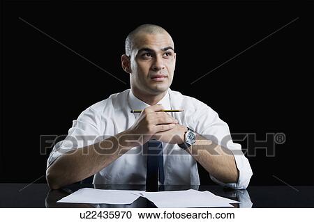 Businessman sitting at a table and thinking View Large Photo Image Stock Image - Businessman sitting at a table and thinking. Fotosearch