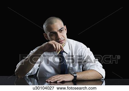Stock Photo - Businessman sitting at a table and thinking. Fotosearch