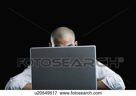 Stock Photo - Businessman sitting in front of a laptop. Fotosearch