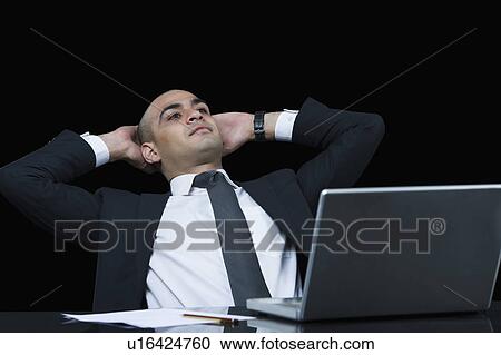Stock Image - Businessman sitting in office and thinking. Fotosearch