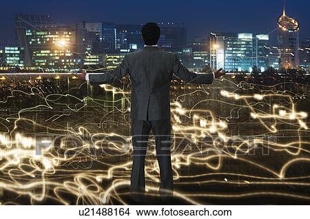 Picture - Businessman standing in front of a city. Fotosearch