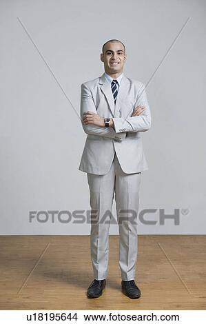 Picture - Businessman standing with his arms crossed and smiling. Fotosearch