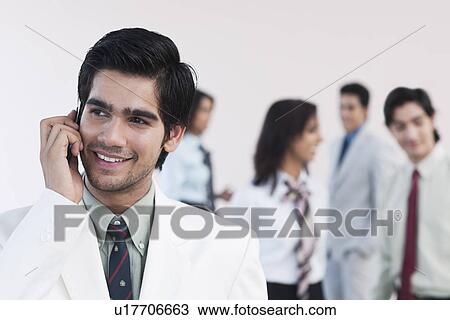 Businessman talking on a mobile phone View Large Photo Image Stock Image - Businessman talking on a mobile phone. Fotosearch