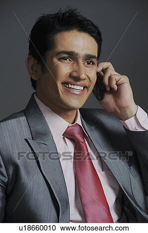 Stock Image - Businessman talking on a mobile phone and smiling. Fotosearch