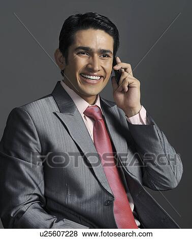 Stock Photo - Businessman talking on a mobile phone and smiling. Fotosearch
