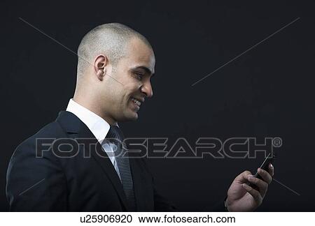 Businessman text messaging on a mobile phone View Large Photo Image Stock Image - Businessman text messaging on a mobile phone. Fotosearch