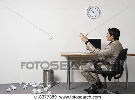 Stock Photo - Businessman throwing crumpled paper into garbage bin. Fotosearch