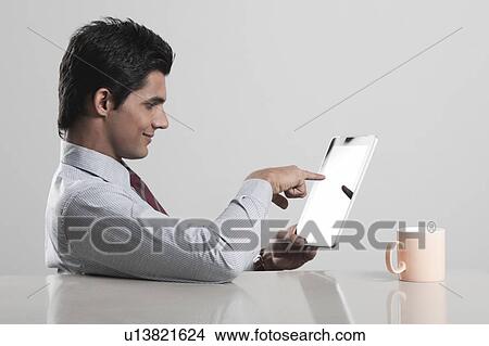 Picture - Businessman using a digital tablet. Fotosearch