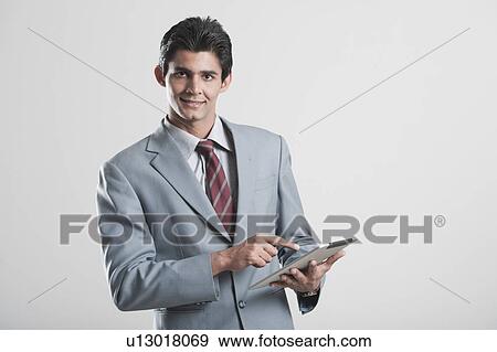 Businessman using a digital tablet View Large Photo Image Stock Photo - Businessman using a digital tablet. Fotosearch