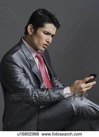 Businessman using a mobile phone View Large Photo Image Stock Photo - Businessman using a mobile phone. Fotosearch