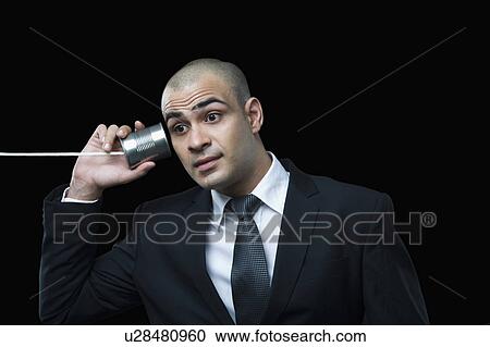 Stock Image - Businessman using tin can phone. Fotosearch