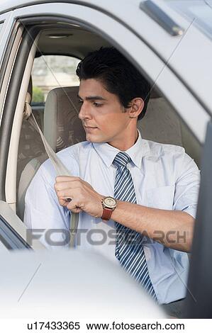 Businessman wearing seat belt in a car, Gurgaon, Haryana, India View Large Photo Image Stock Photography - Businessman wearing seat belt in a car, Gurgaon, Haryana, India. Fotosearch