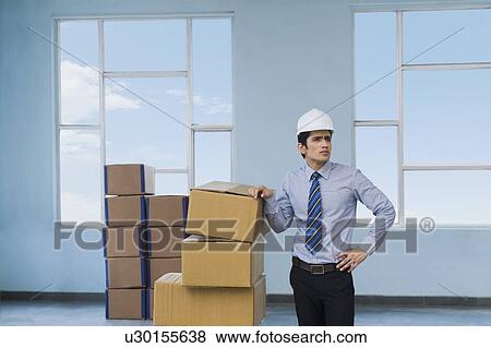 Businessman with cardboard boxes in a warehouse View Large Photo Image Stock Photo - Businessman with cardboard boxes in a warehouse. Fotosearch