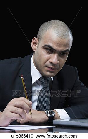 Businessman working in front of a laptop View Large Photo Image Stock Image - Businessman working in front of a laptop. Fotosearch