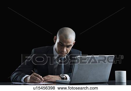 Businessman working in front of a laptop View Large Photo Image Stock Photo - Businessman working in front of a laptop. Fotosearch