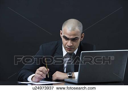Stock Photo - Businessman working in front of a laptop. Fotosearch