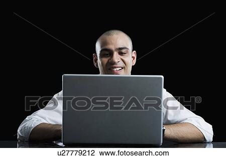 Businessman working on a laptop View Large Photo Image Stock Image - Businessman working on a laptop. Fotosearch
