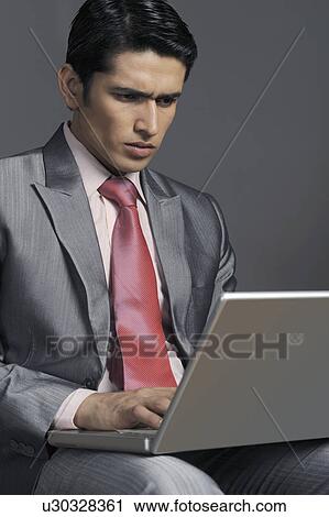 Businessman working on a laptop View Large Photo Image Stock Image - Businessman working on a laptop. Fotosearch