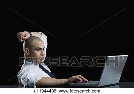 Businessman working on a laptop View Large Photo Image Stock Photo - Businessman working on a laptop. Fotosearch