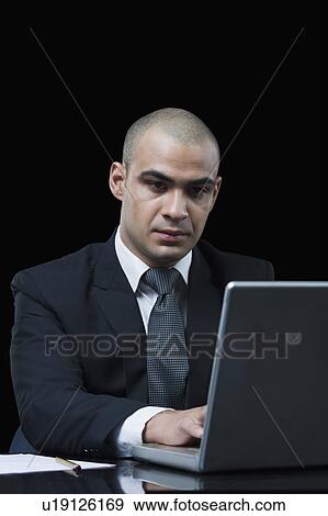 Businessman working on a laptop View Large Photo Image Stock Photo - Businessman working on a laptop. Fotosearch