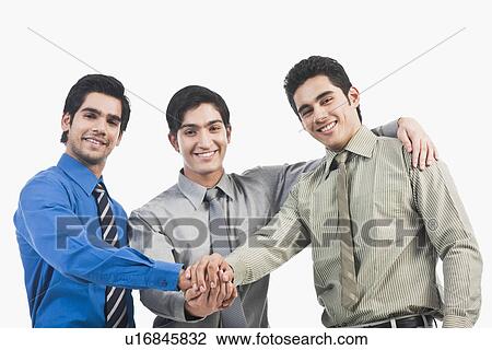 Stock Image - Businessmen stacking hands. Fotosearch
