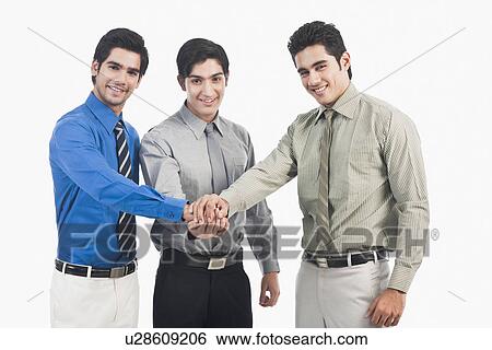 Stock Photograph - Businessmen stacking hands. Fotosearch