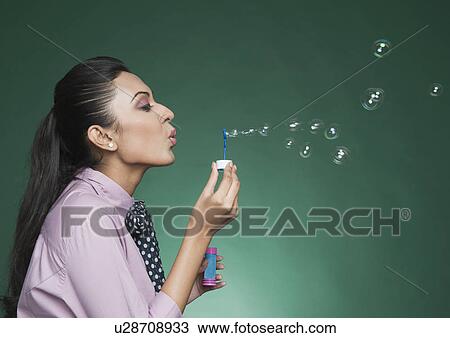 Businesswoman blowing bubbles with a bubble wand View Large Photo Image Stock Image - Businesswoman blowing bubbles with a bubble wand. Fotosearch